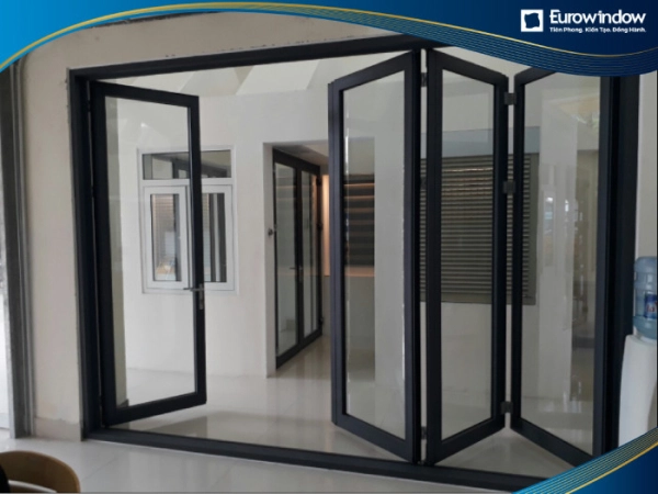 Cửa đi nhôm 4 cánh xếp trượt sử dụng tại tòa nhà văn phòng không những không cản trở lối đi mà còn có thể mở rộng liên kết các không gian.