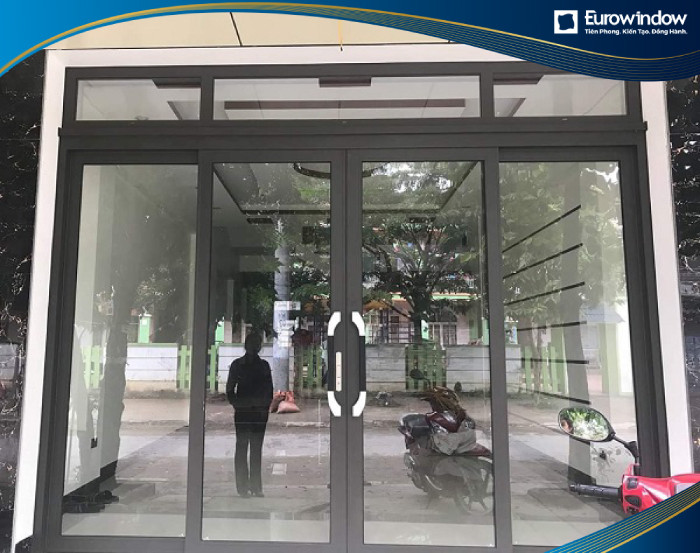 Cửa đi nhôm mở trượt quay có màu sắc hiện đại, kiểu dáng đơn giản lắp đặt tại lối ra vào chính nhà lô phố.