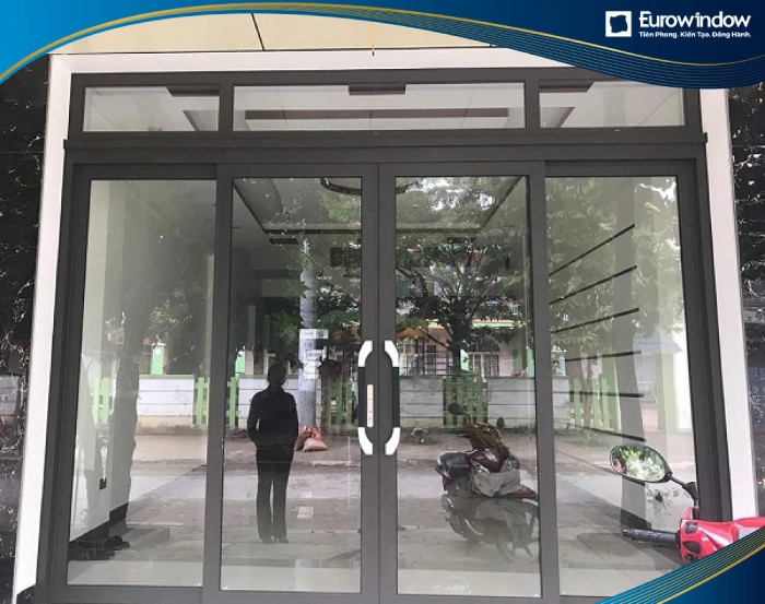 Cửa đi nhôm mở trượt quay có màu sắc hiện đại, kiểu dáng đơn giản lắp đặt tại lối ra vào chính nhà lô phố.