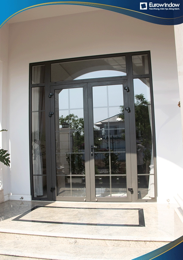 Cửa nhôm mở quay màu đen nhám 2 cánh kết hợp 2 vách hai bên và chia ô trang trí làm cửa đi tại phòng khách