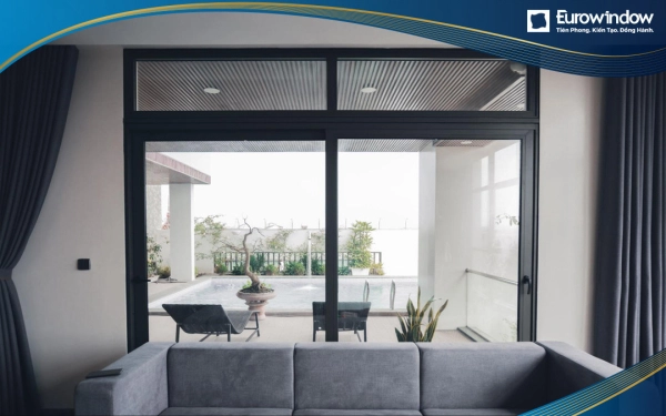 Mẫu cửa lùa nhôm 2 cánh màu đen cỡ lớn được lắp đặt tại lối ra bể bơi gia đình, vừa tiết kiệm diện tích vừa tận dụng được view thoáng cho phòng khách phía trong