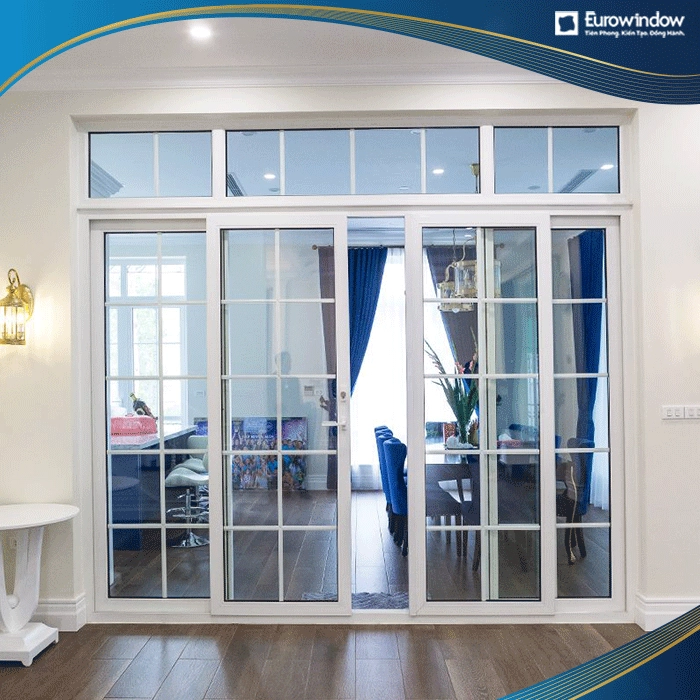 Cửa đi nhôm 4 cánh mở trượt có thanh nan trang trí và vách kính cố định bên trên giúp không khí lưu thông kể cả khi đóng cửa