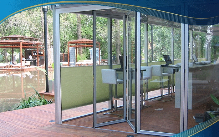 Cửa đi nhôm xếp trượt 4 cánh màu xám cho quán cà phê, khi mở hết các cánh tạo lối đi rộng rãi và tạo cảm giác hoà hợp với thiên nhiên