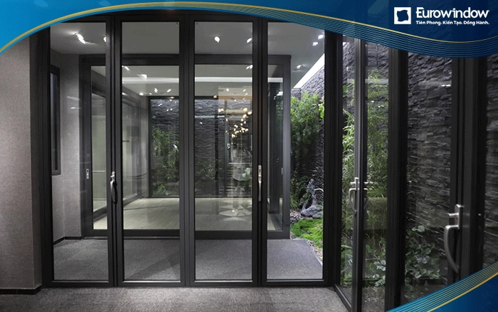 Cửa nhôm cao cấp mở quay kết hợp với vách kính cố định màu đen ghi thay thế toàn bộ các mảng tưởng