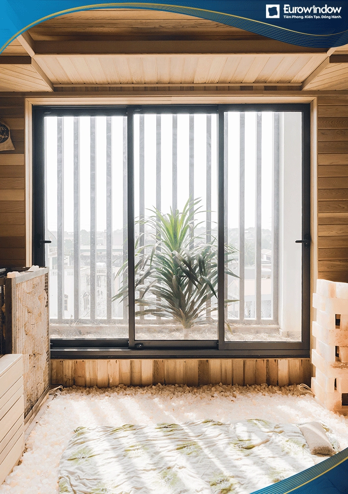 Với những phòng có diện tích ban công nhỏ hẹp, Eurowindow sử dụng cửa nhôm cao cấp mở trượt. Cửa màu xám ghi kết hợp với tone màu be của phòng càng làm không gian thêm ấm áp