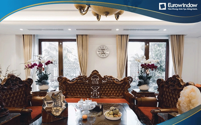 Không gian phòng khách sang trọng, quý tộc với bộ bàn ghế gỗ sơn bóng loáng. Eurowindow thiết kế 2 cửa đi mở quay ở 2 bên để tạo sự cân xứng