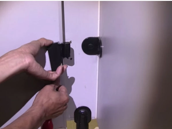 Tháo nắp che vít của bản lề bằng tua vít 2 cạnh