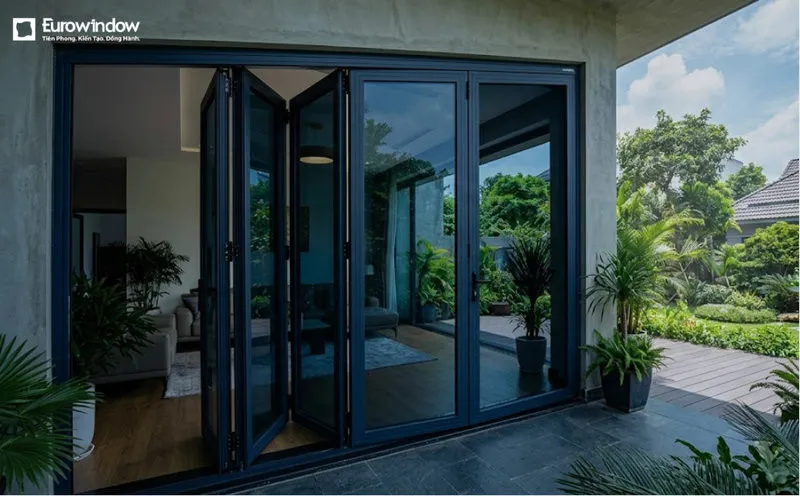 Cửa đi nhôm kính xanh đen xếp trượt nhiều cánh, mở rộng không gian và kết nối với khu vực sân vườn bên ngoài. (Nguồn: Eurowindow)