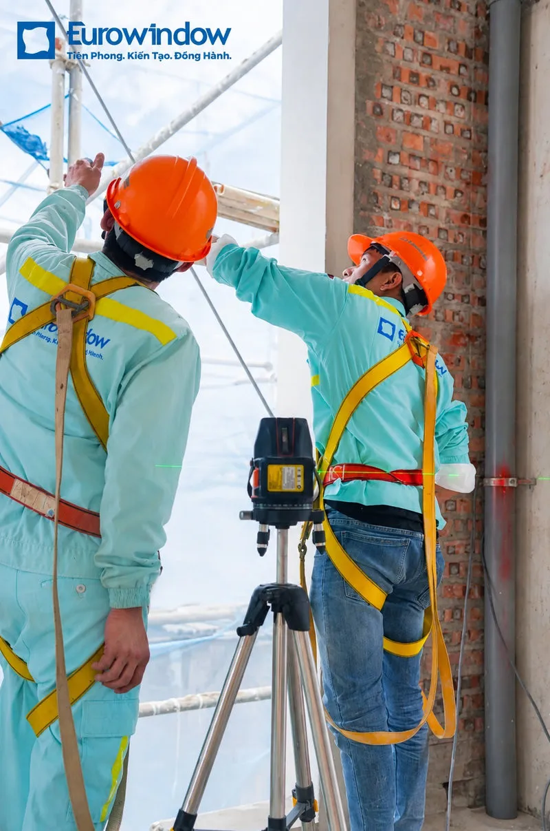 Thợ thi công Eurowindow sử dụng máy laser đo đạc và cân chỉnh mặt phẳng lắp đặt cửa