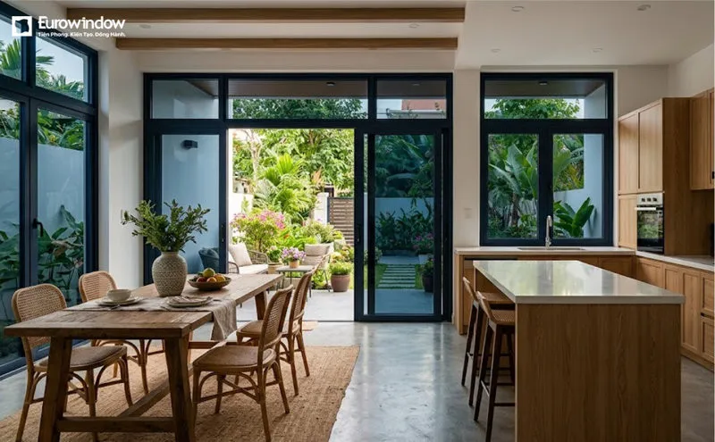Mẫu cửa nhôm kính xanh đen tạo sự kết nối hài hòa giữa khu vực bếp, phòng ăn và không gian xanh bên ngoài. (Nguồn: Eurowindow)